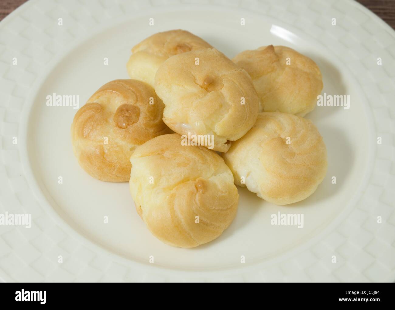 Snack et un dessert délicieux fraîchement fait maison, choux farci de crème Crème Crème anglaise ou de la crème fouettée. Banque D'Images