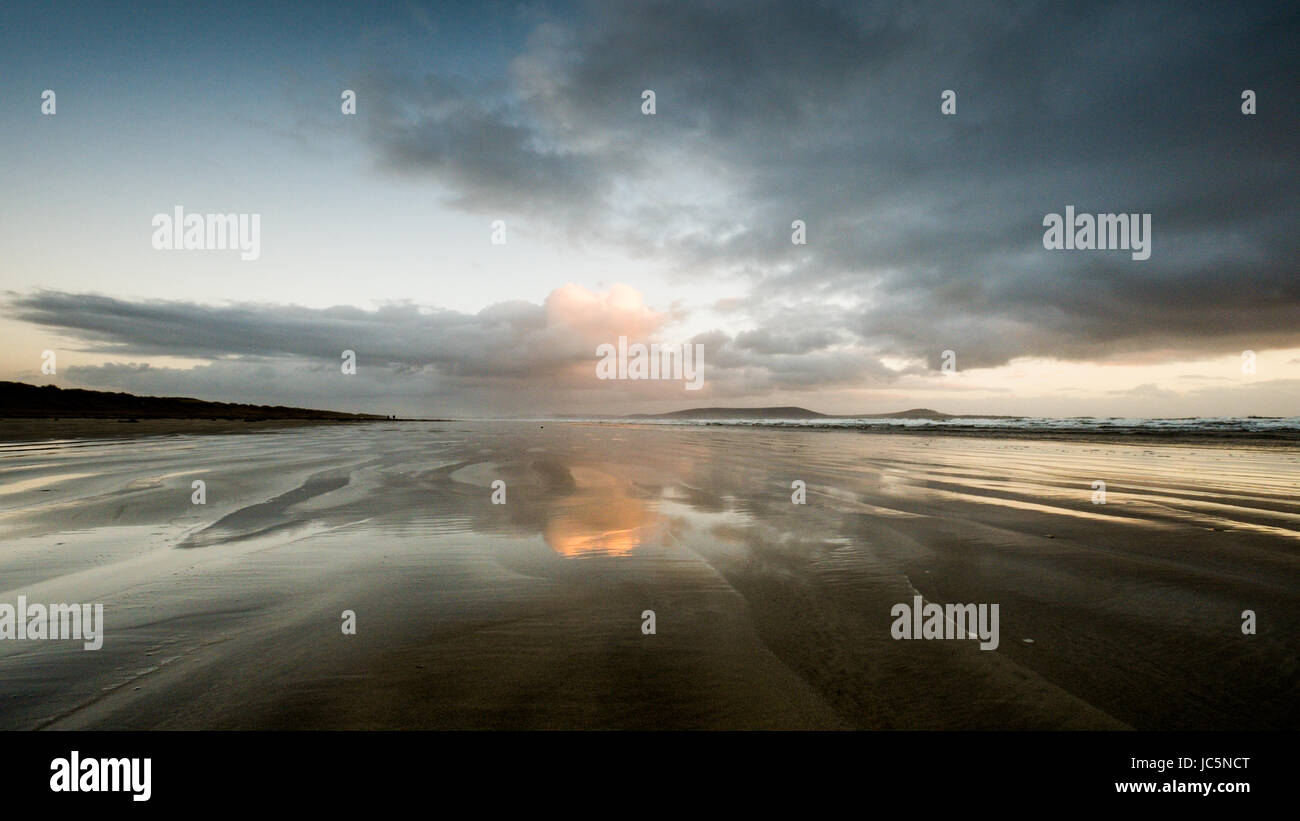 Nuageux nuages sombres et réfléchi à Pembrey Plage (Cefn Sidan). Carmarthenshire. Le Pays de Galles. UK Banque D'Images