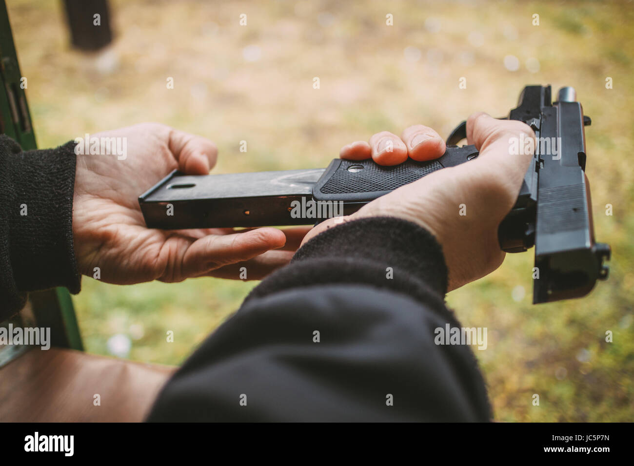 Close-up of a man hands holding et des armes à feu dans le magasin de chargement au pistolet de tir. Banque D'Images