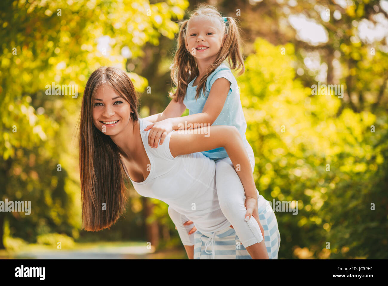 Belle Mère et fille s'amuser au parc au printemps. Jeune mère usurpation de sa fille. Banque D'Images