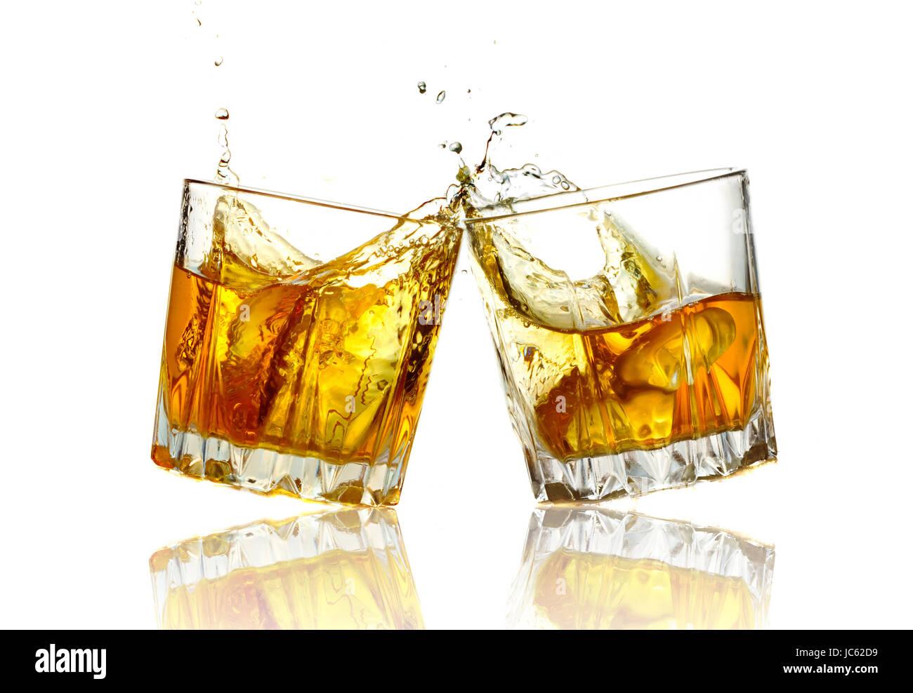 Deux verres de whisky de trinquer ensemble, isolé sur blanc. Banque D'Images