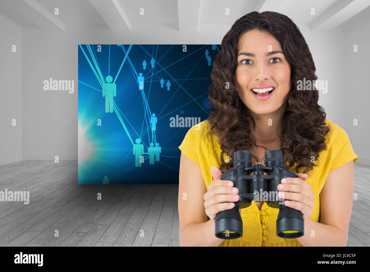 Composite image of smiling casual young woman holding binoculars Banque D'Images