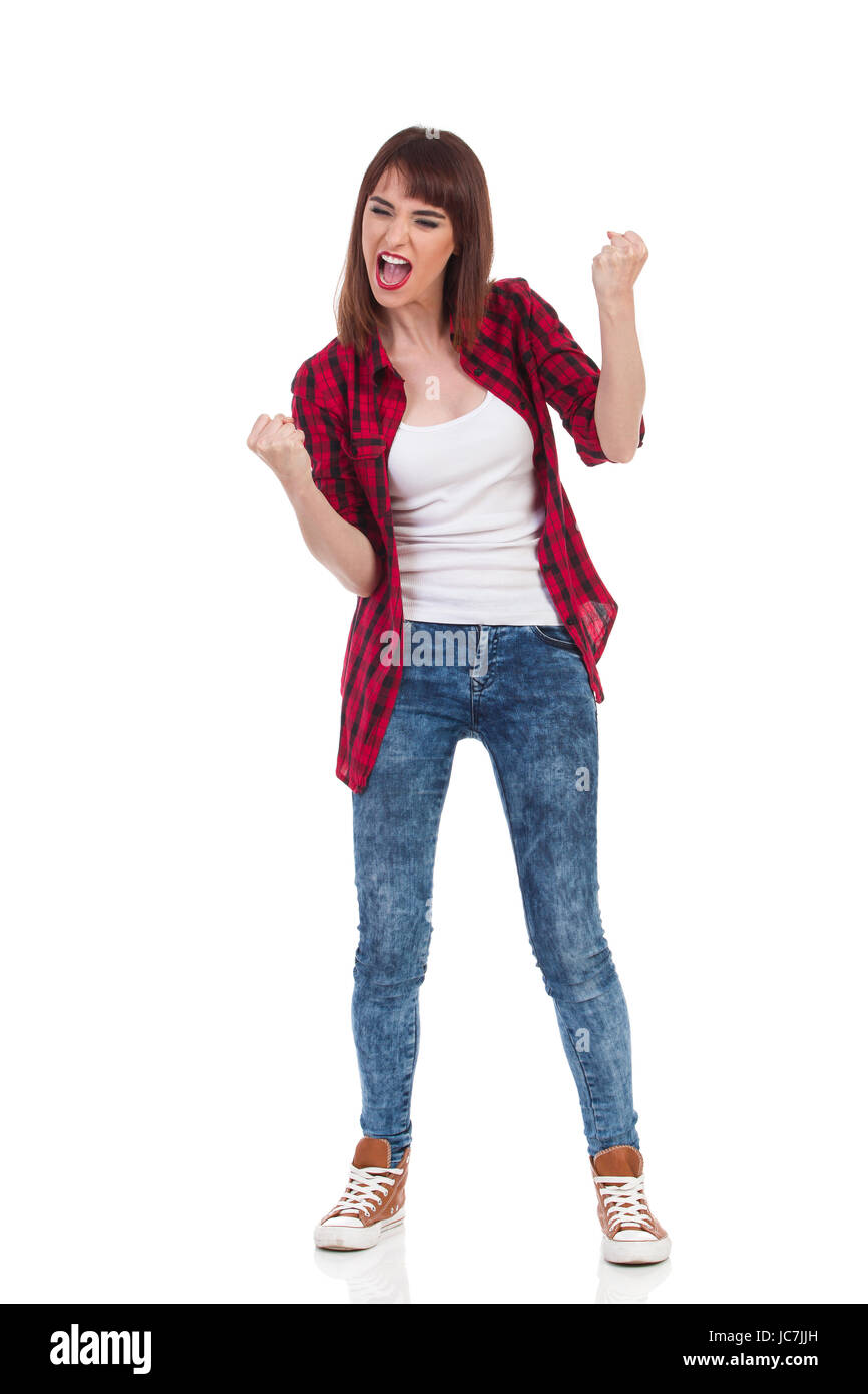 Jeune femme en chemise de bûcheron rouge déboutonnée et un jean serre les  poings et hurle. Studio pleine longueur shot isolé sur blanc Photo Stock -  Alamy