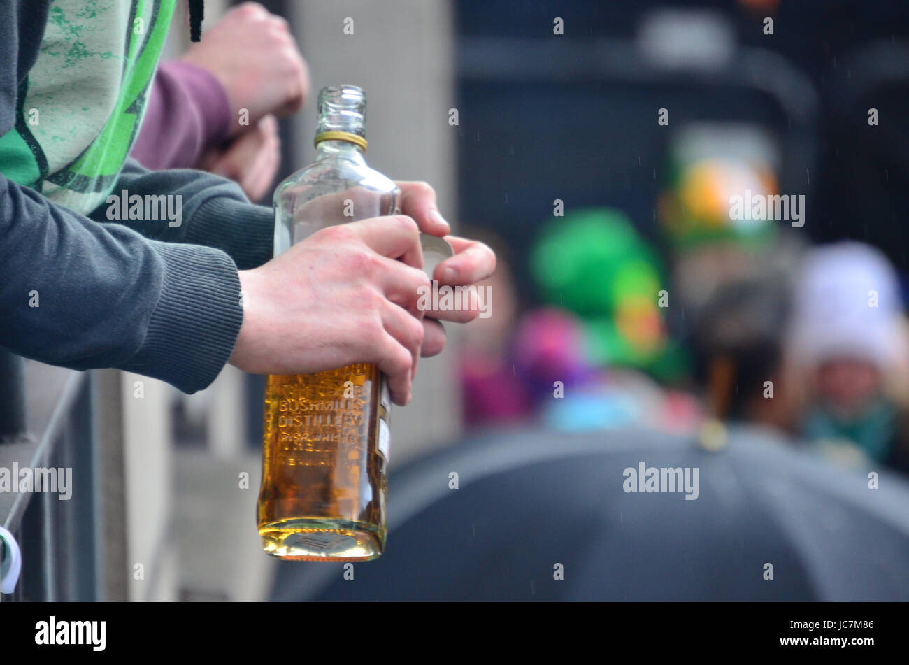Une main tenant une bouteille de whisky irlandais Banque D'Images