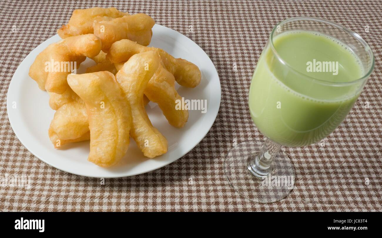 Snack et dessert, des en-cas traditionnel chinois Frits Doughstick sur plaque blanche servi avec du lait de Soja Thé vert. Banque D'Images