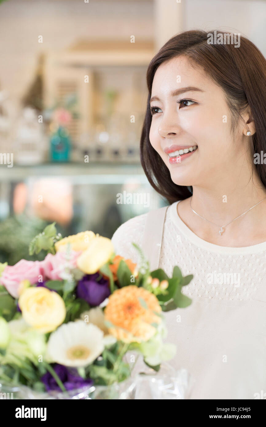 Portrait of young smiling woman with flowers Banque D'Images