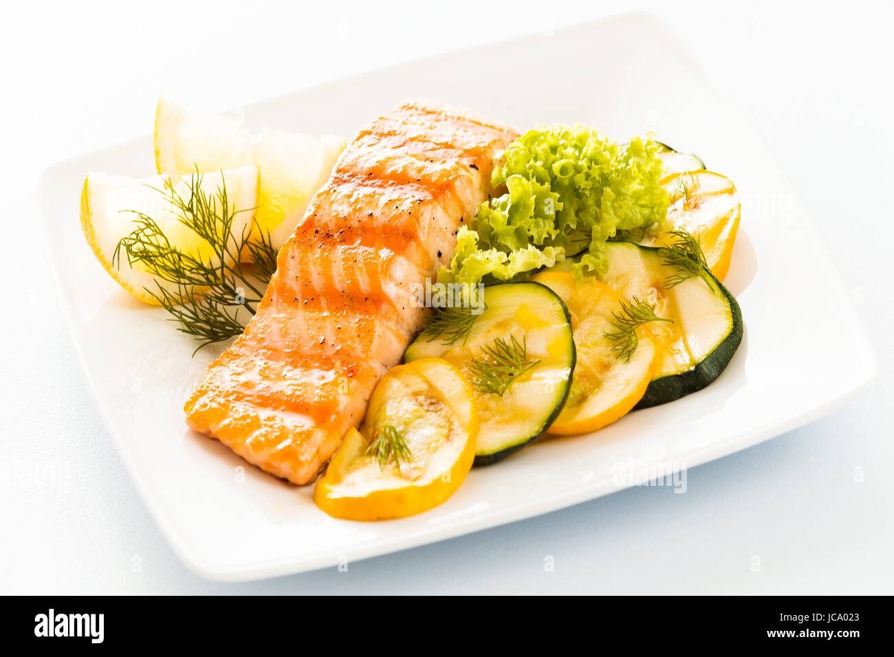 Pavé de saumon avec des tranches de courgettes et les courgettes, la laitue et garnir de citron de l'aneth frais pour un délicieux plateau de fruits de mer ou d'apéritif Banque D'Images