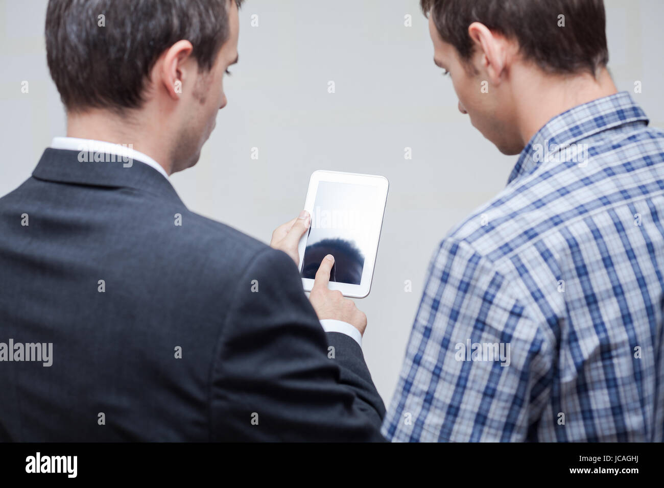 Vue arrière des deux hommes d'using digital tablet. Banque D'Images