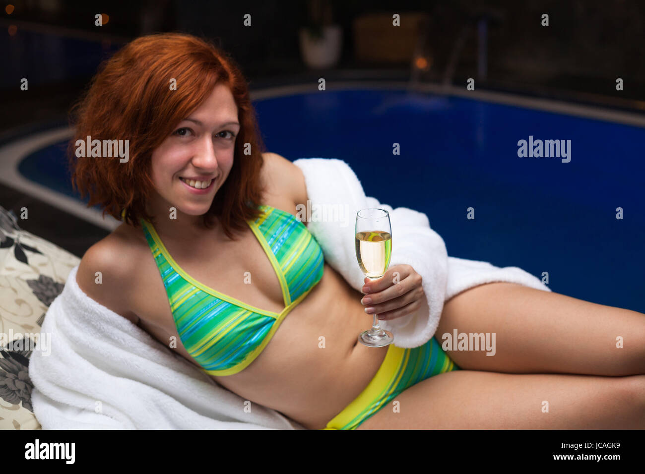 Femme avec verre de vin bénéficiant d'une piscine spa et bien-être. Banque D'Images