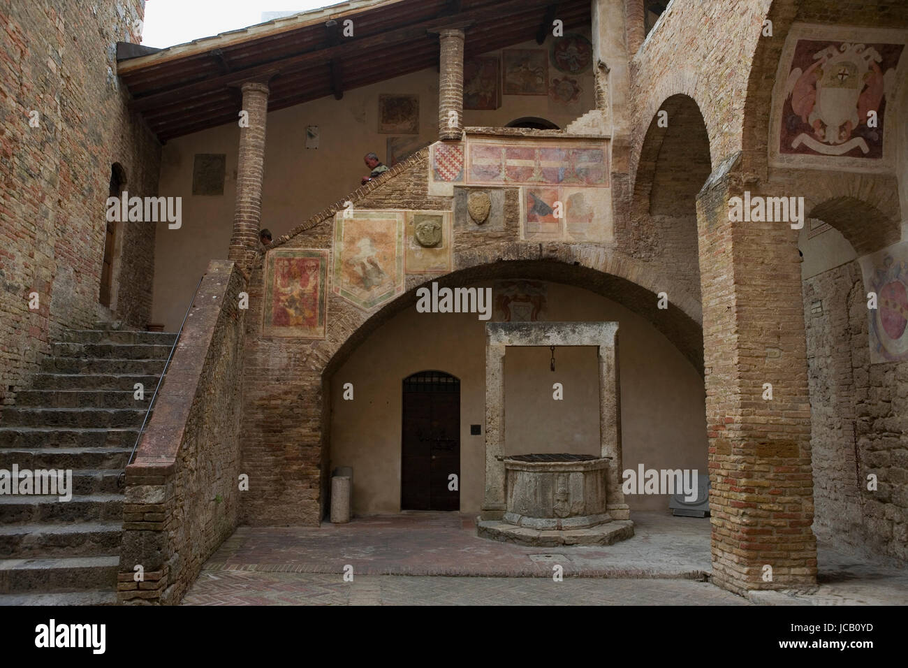 Jolie cour dans le Palazzo del Popolo, avec des fragments de fresques par Sodoma : San Gimignano, Toscane, Italie Banque D'Images