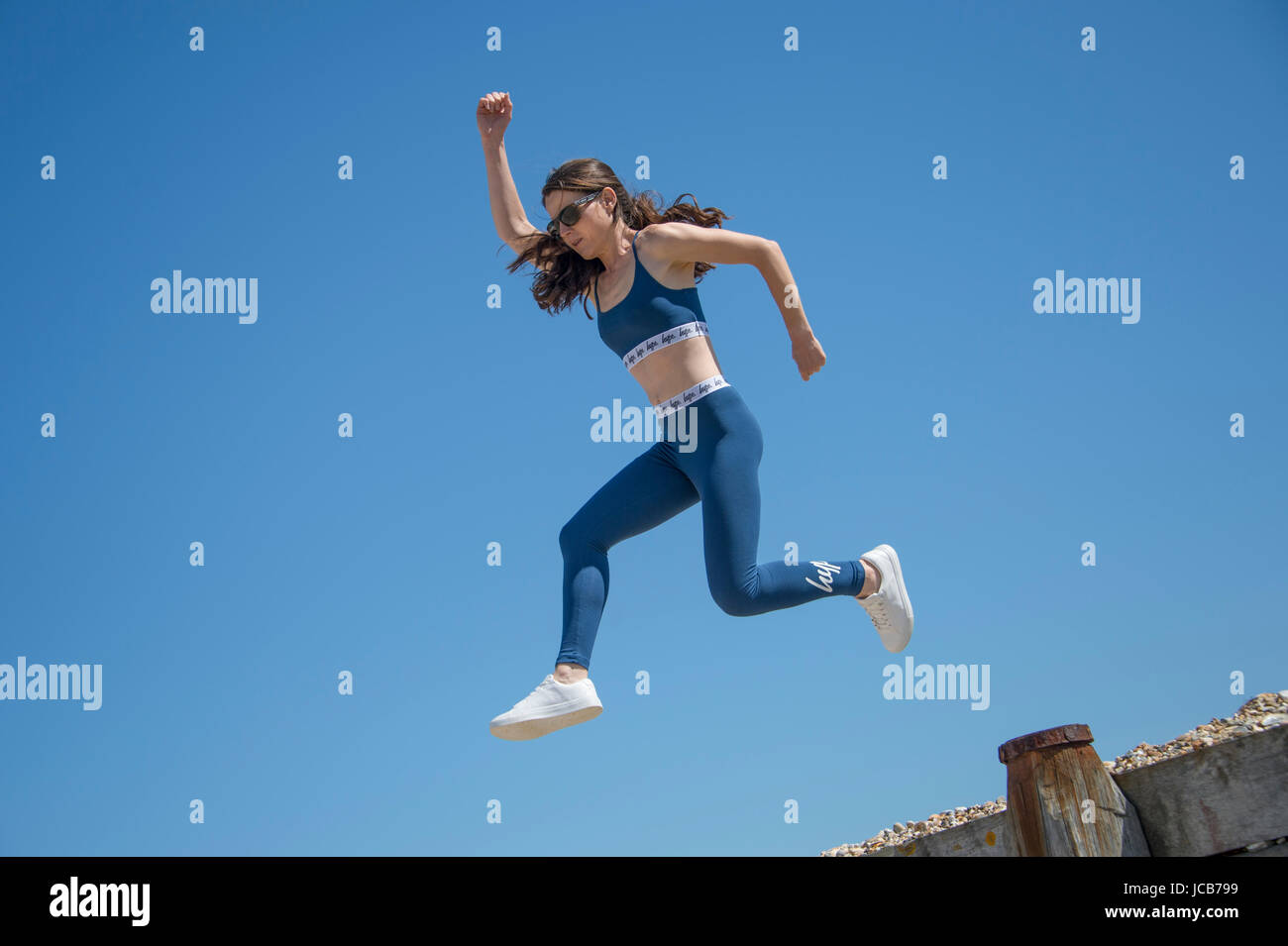 Femme faisant un saut exécuté sur la plage Banque D'Images