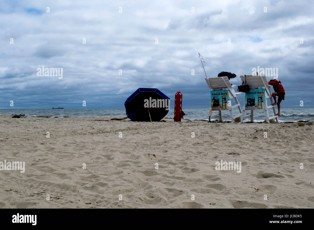 Plage surveillée à Rehoboth Beach, DE, de service en cours de jour de tempête avec l'expédition dans la distance. Banque D'Images