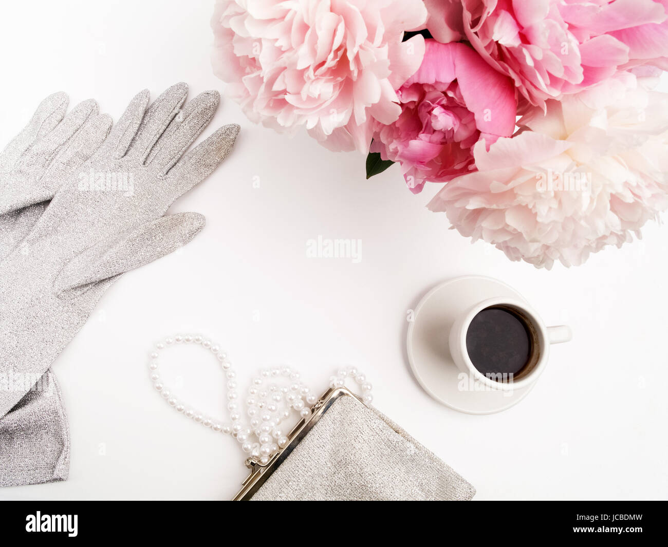 Nature morte à la tasse de café, de fleurs de pivoines et des gants sur table lumineuse. Banque D'Images