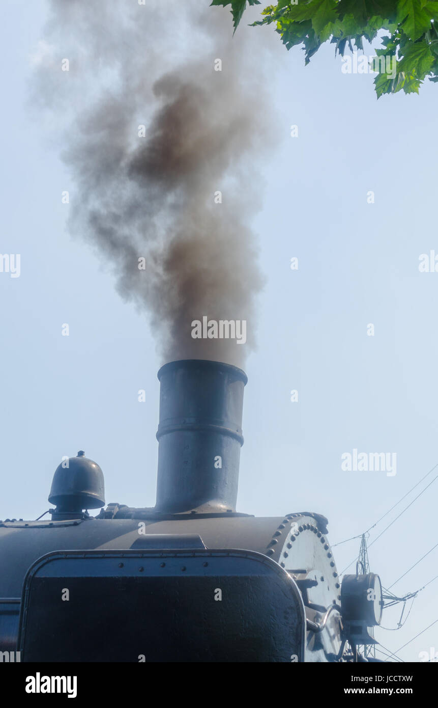 Dampf Lokomotive unter Volldampf bei der Ausfahrt aus einem Bahnhof. Banque D'Images