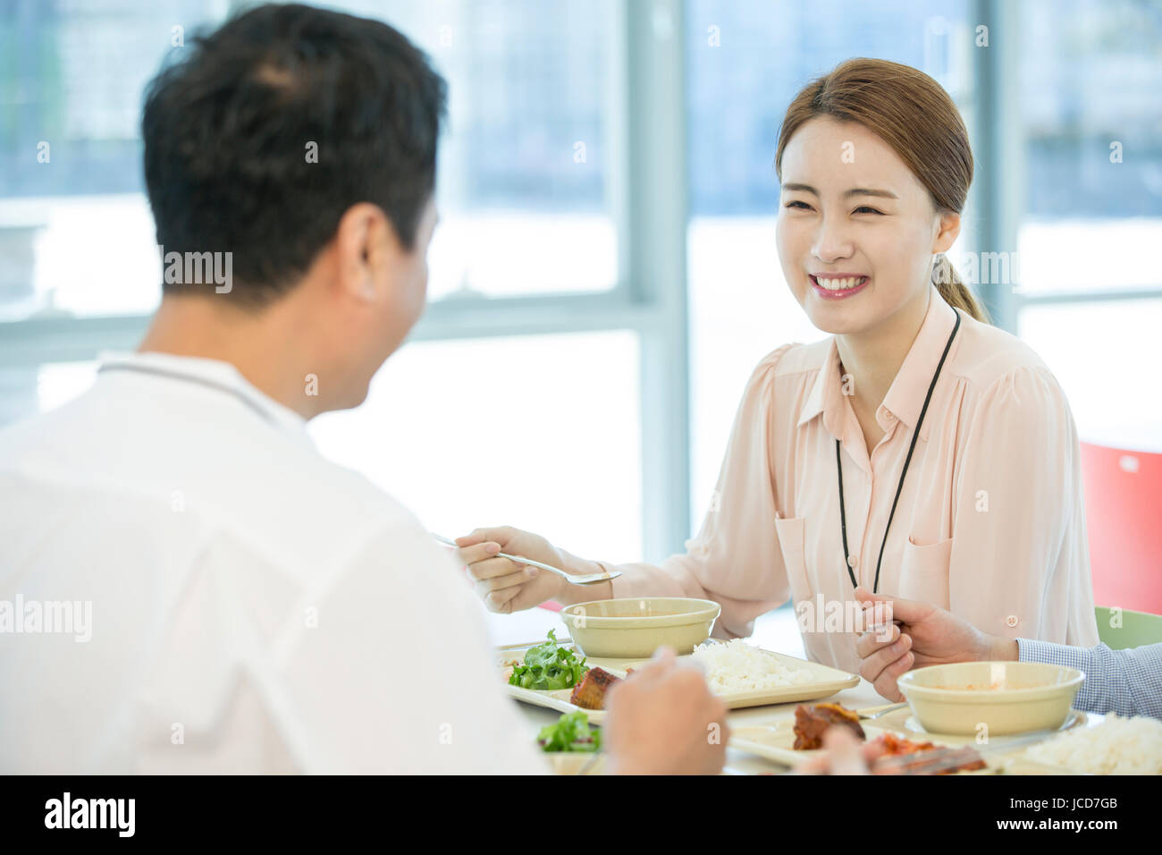 Smiling businesswoman talking with coworker pendant les repas Banque D'Images