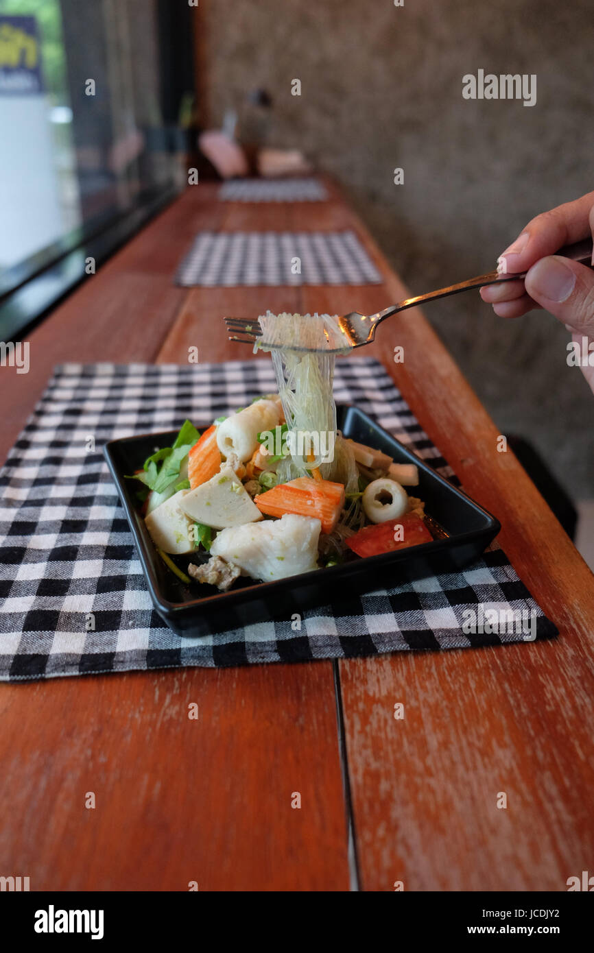 Salade thaïlandaise épicée et aigre à la tomate, fruits de mer nouilles de verre, le céleri porc et crevette cafe Banque D'Images