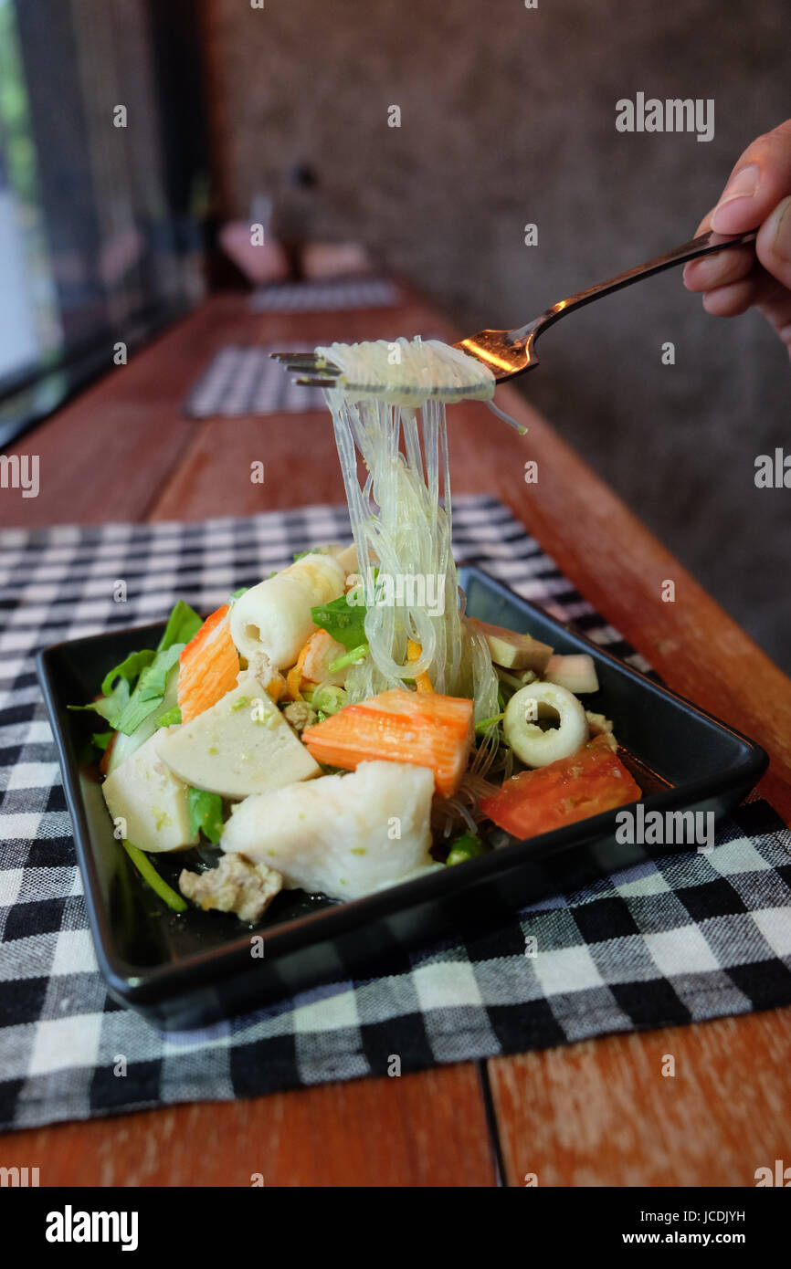 Salade thaïlandaise épicée et aigre à la tomate, fruits de mer nouilles de verre, le céleri porc et crevette cafe Banque D'Images