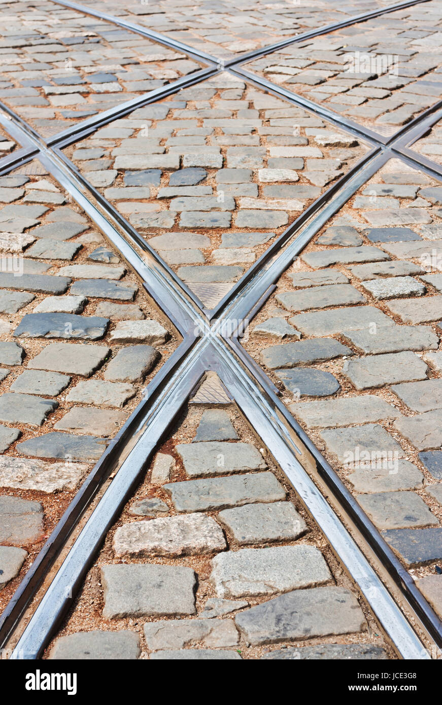 Les rails du tramway traversant rue voiture sur une rue pavée Banque D'Images