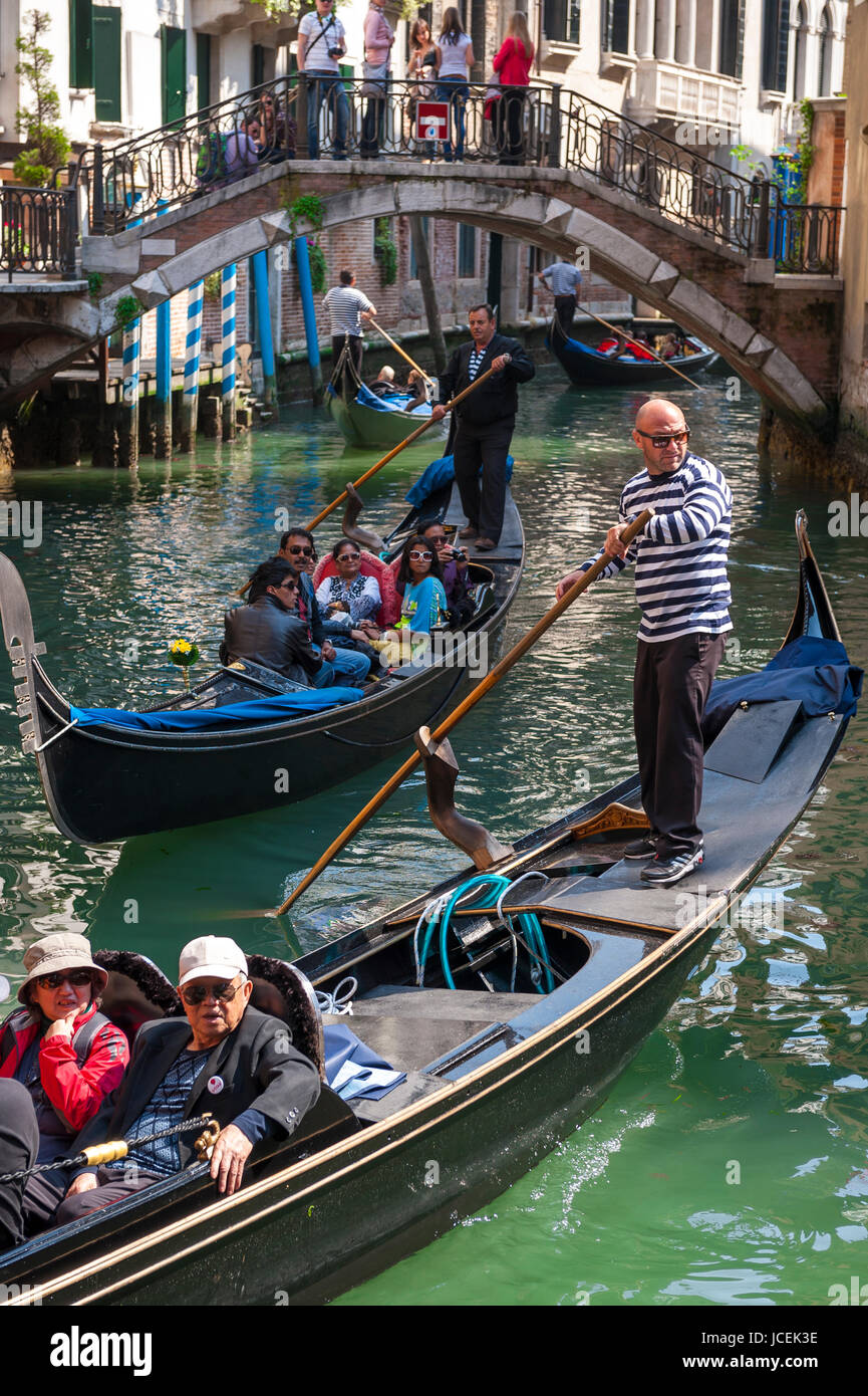 Venise, Italie - CIRCA AVRIL 2013 : gondolier vénitien plates ses eaux vert le long de la gondole d'un canal. Banque D'Images
