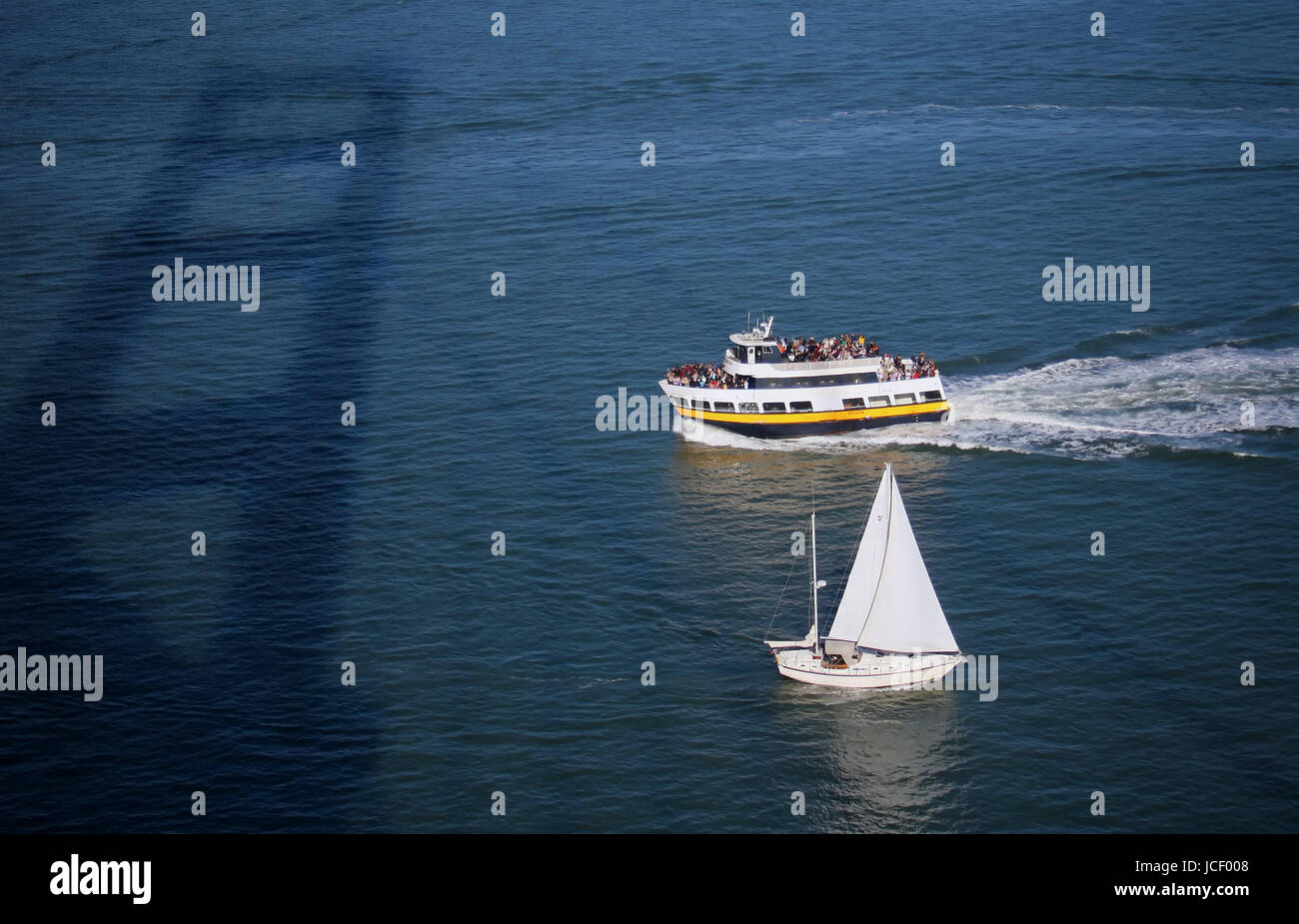 Un ferry et croisière en bateau à voile sous le Golden Gate Bridge dans la baie de San Francisco. Banque D'Images
