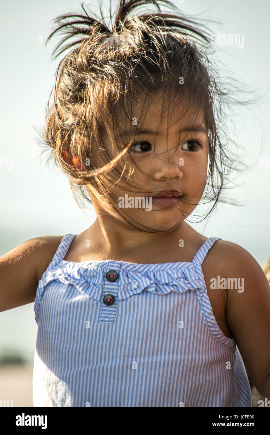 Une petite fille aux cheveux vent jeté en l'air à sa gauche avec un léger  sourire Photo Stock - Alamy