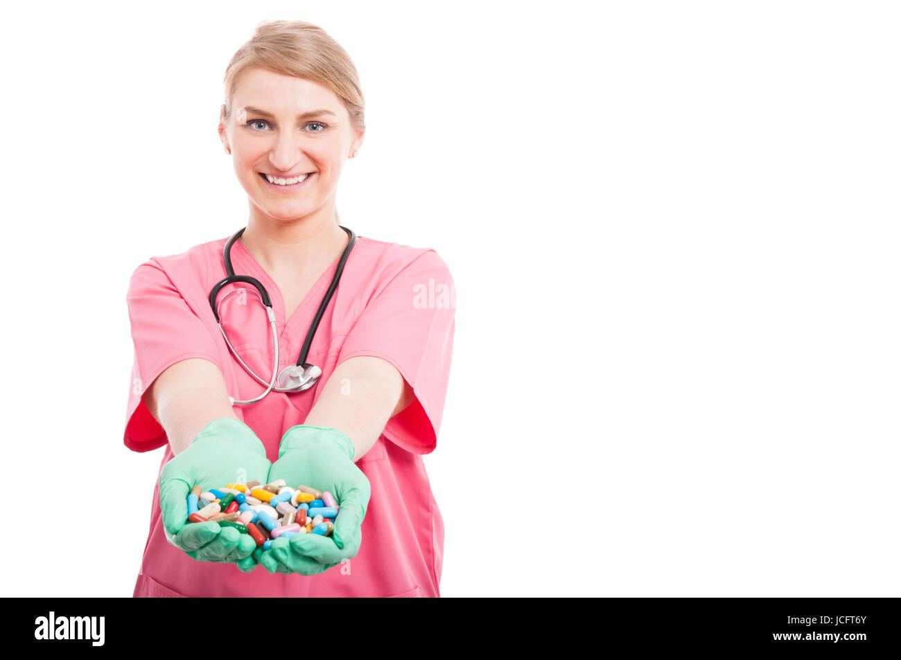 Friendly infirmière médicale lady smiling montrant beaucoup de pilules isolé sur fond blanc avec l'espace texte copie Banque D'Images