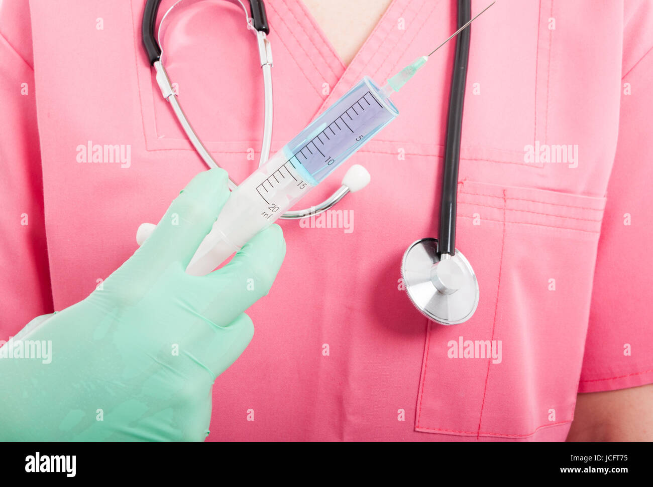 Close-u de medical nurse holding syringe wearing scrubs rose isolé sur fond blanc Banque D'Images