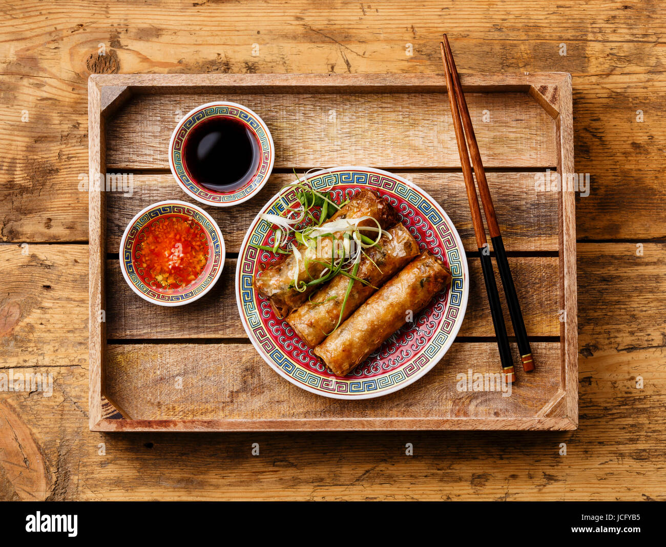 Des rouleaux de printemps avec sauce au plateau en bois sur fond de bois Banque D'Images