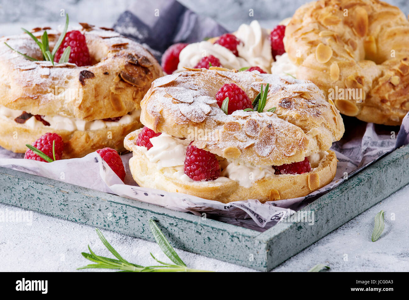 Gateau De Pate A Choux Maison Paris Brest Avec Des Framboises L Amande Le Sucre En Poudre Et Le Romarin Servi Sur Plateau De Service En Bois Plus Gris Bleu Texture Backg Photo Gateau De Pate A Choux Maison Paris Brest Avec Des Framboises L Amande Le Sucre En Poudre Et Le Romarin Servi Sur Plateau De Service En Bois Plus Gris Bleu Texture Backg Photo