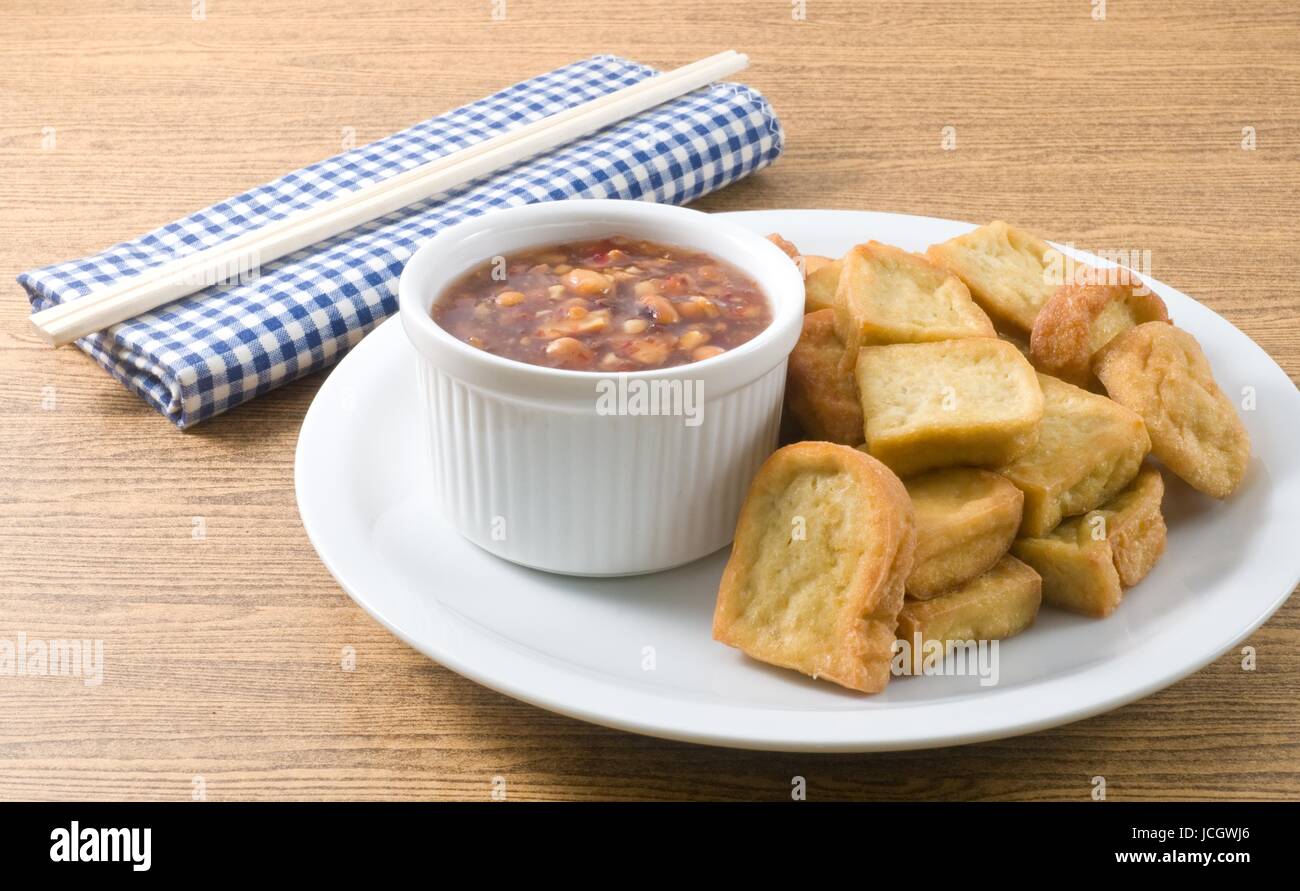 Snack et dessert, assiette de tofu frit traditionnel chinois ou caillé de soja frit servi avec sauce épicée et aigre douce. Banque D'Images