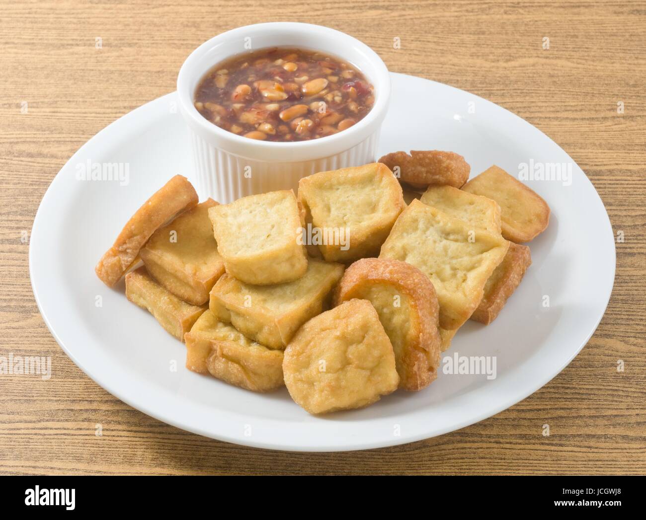 Snack et dessert, le tofu frit chinois ou caillé de soja frit servi avec sauce épicée et aigre douce. Banque D'Images