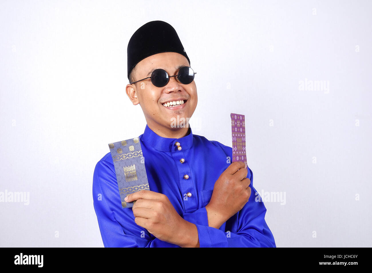 L'homme en costume traditionnel de bonne humeur avec paquet d'argent au cours de célébrer l'aïd Fitr. Banque D'Images