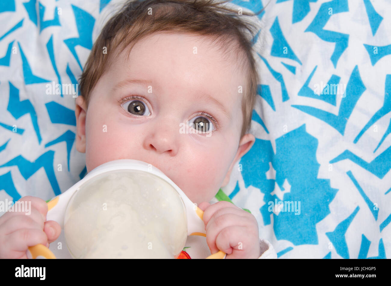 Six mois du lait de consommation à partir d'une bouteille avec la tétine Banque D'Images