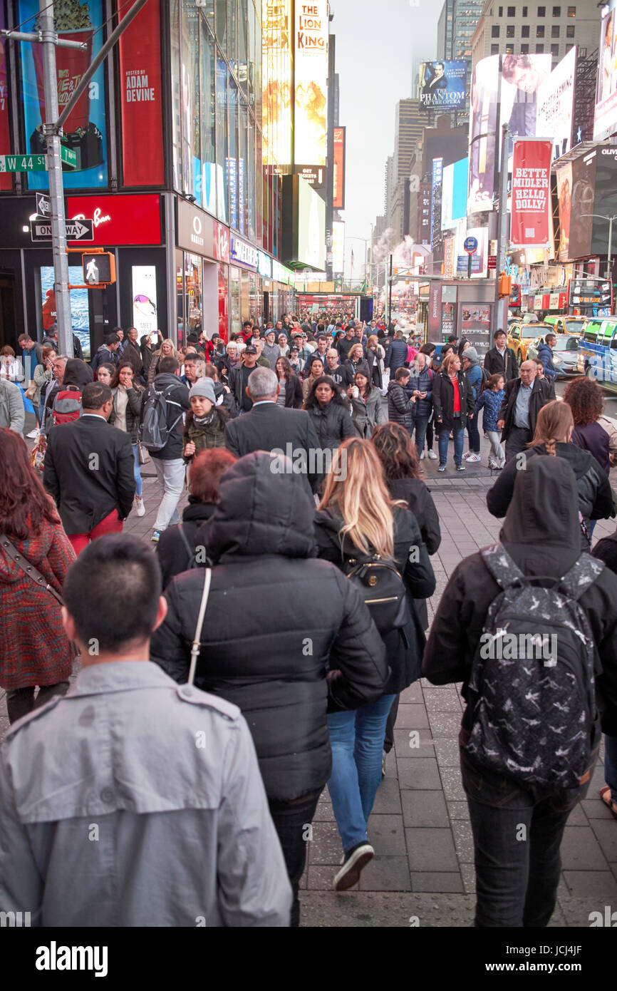 Les personnes qui traversent la pleine concordance de trottoir occupé dans la soirée soirée à Times Square New York City USA Banque D'Images