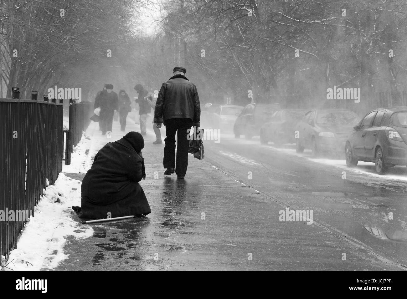 Moscou, Russie, le 24 mars 2011 : La vieille femme demande l'aumône, assis sur le trottoir pendant la tempête de neige. Banque D'Images