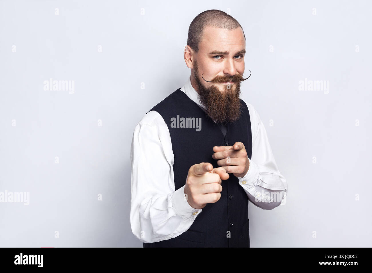 Hey you. Handsome businessman avec barbe et moustache à la caméra au guidon. studio shot, sur fond gris. Banque D'Images