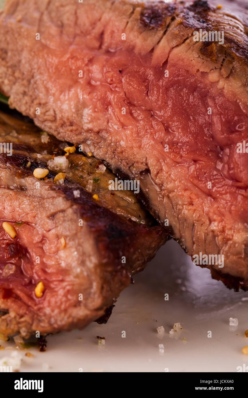 Rindersteak gebratenes moyen filet mit Pfeffer und rosmarin aufgeschnitten vor isoliert auf einem Teller weißem Hintergrund Banque D'Images