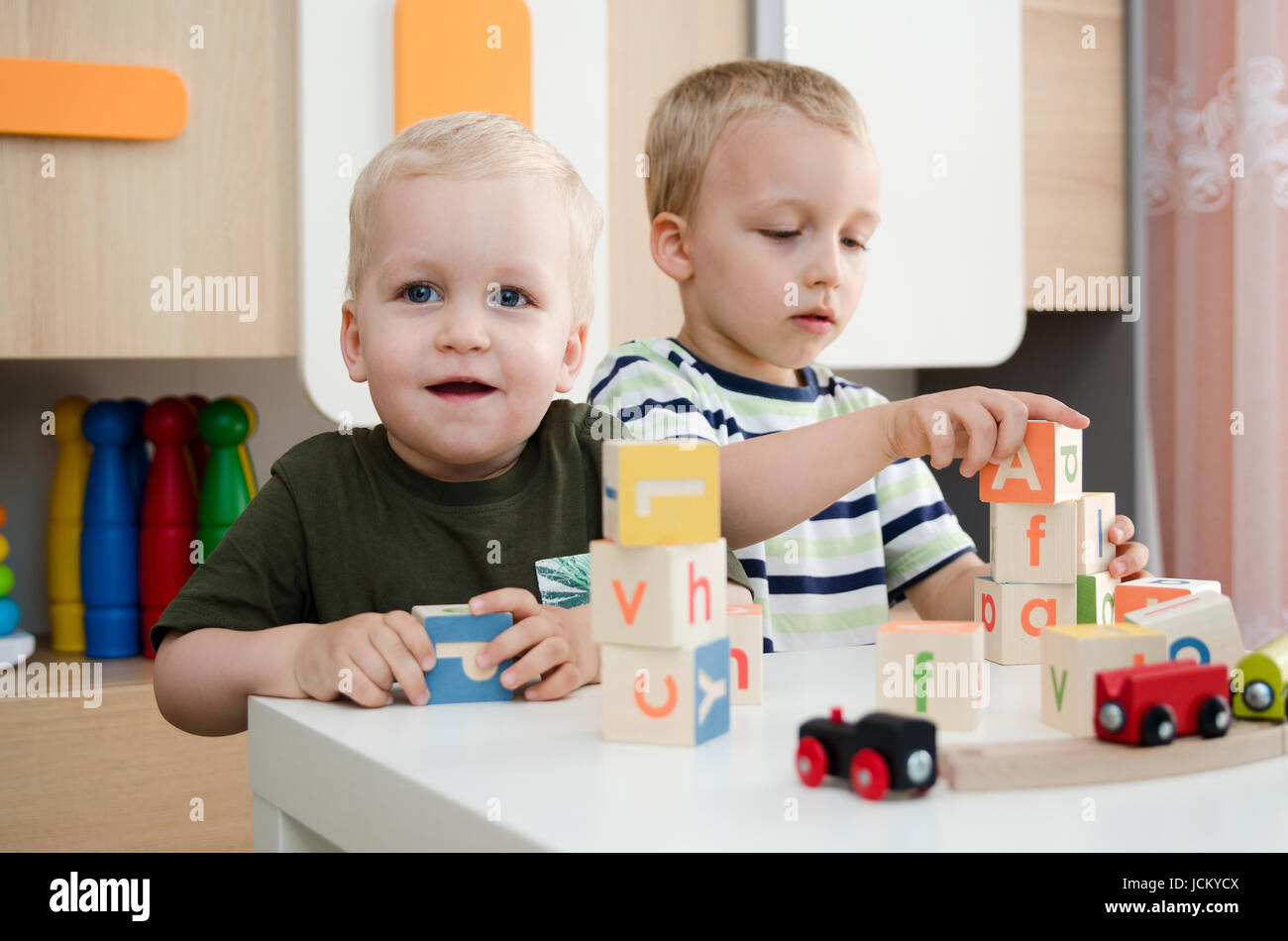 Enfants garçons jouant avec des blocs de jouets à la maison ou au jardin d'enfants d'âge préscolaire à l'école maternelle. L'école garderie enfant concept coloré Banque D'Images