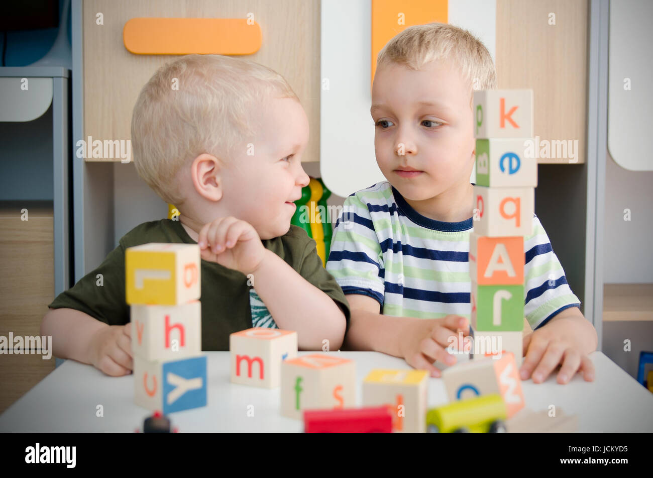 Enfants garçons jouant avec des blocs de jouets à la maison ou au jardin d'enfants d'âge préscolaire à l'école maternelle. L'école garderie enfant concept coloré Banque D'Images