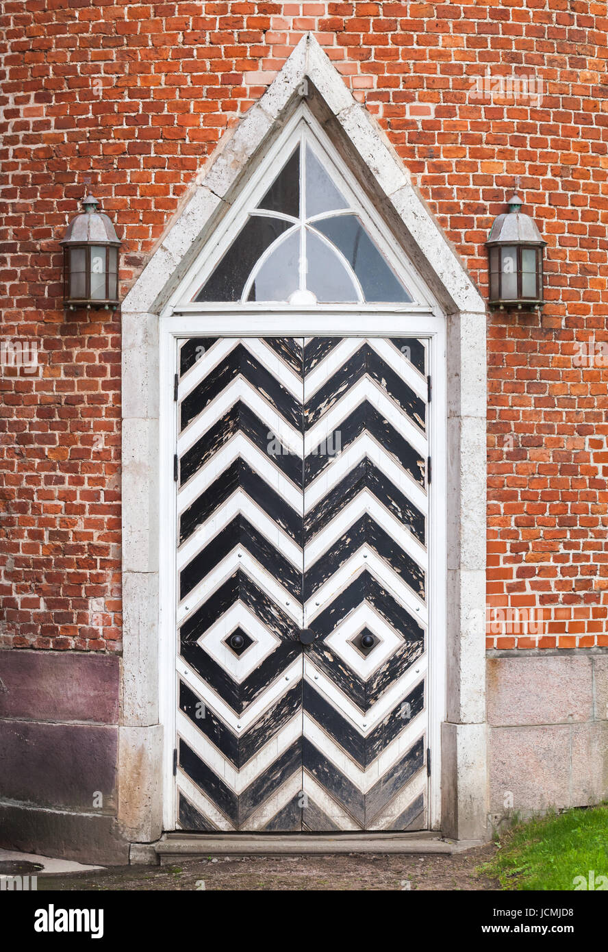 La porte en bois en mur de briques rouges, architecture néo-gothique de style. La texture d'arrière-plan Banque D'Images