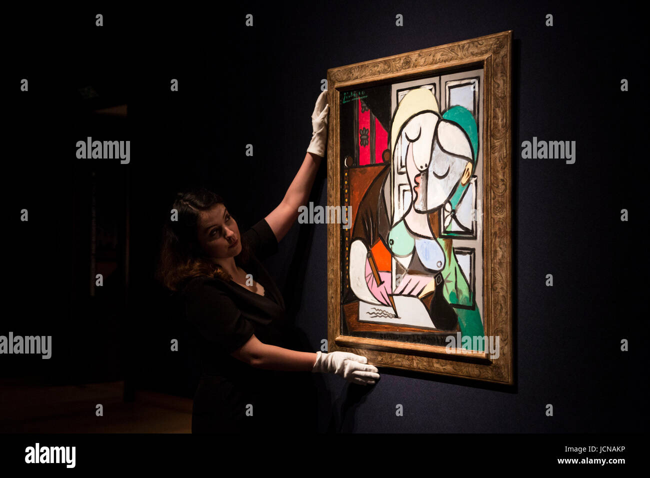 Londres, Royaume-Uni. 16 juin 2017. Un employé de Christie's s'occupe de la peinture Femem ecrivant (Marie-thérèse), 1934, par Pablo Picasso, estimer GBP 25-40m. Maison de vente aux enchères Christie's présente un aperçu de l'art impressionniste et moderne Art evening sale le 27 juin 2017. La vente fait partie du 20ème siècle pour Christie's et est dirigé par un groupe de tableaux de Max Beckmann, Claude Monet, Pablo Picasso, Egon Schiele et Vincent van Gogh. Banque D'Images
