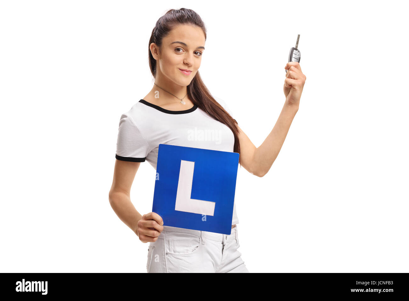 Teenage girl holding une clé de voiture et d'un L-sign isolé sur fond blanc Banque D'Images
