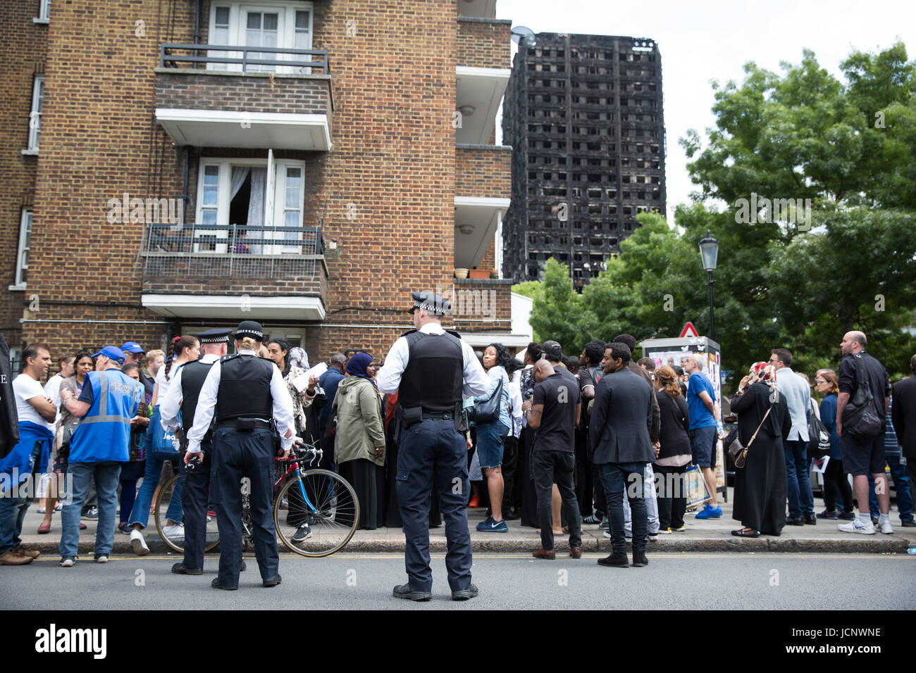 Londres, Royaume-Uni. 16 Juin, 2017. Voix posée entre les membres du public à Bramley Road en face de la carcasse brûlée de la tour de Grenfell. Les agents de police. Credit : Mark Kerrison/Alamy Live News Banque D'Images