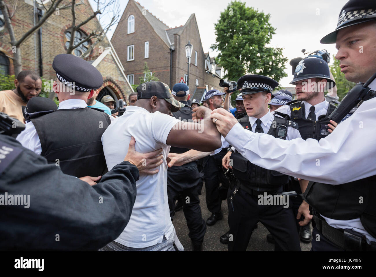 Londres, Royaume-Uni. 16 Juin, 2017. Des échauffourées avec les habitants en colère et la police comme PM Theresa peut quitte St Clement's Church sur Treadgold Street à la hâte sans parler aux résidents concernant l'incendie à proximité de la tour de Grenfell. © Guy Josse/Alamy Live News Banque D'Images