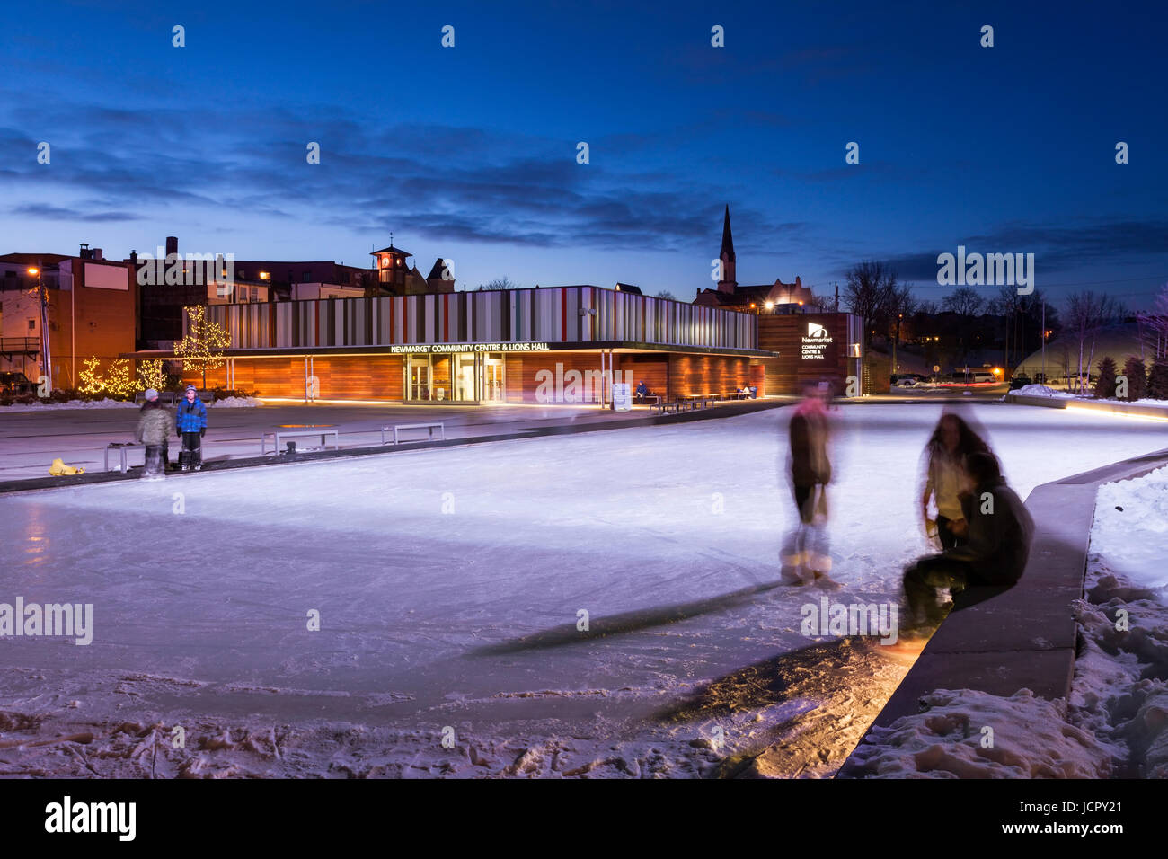 Le Centre communautaire de Newmarket en hiver avec les gens, les patineurs sur glace au crépuscule dans le centre-ville de Toronto, la région de York, Ontario, Canada. Banque D'Images
