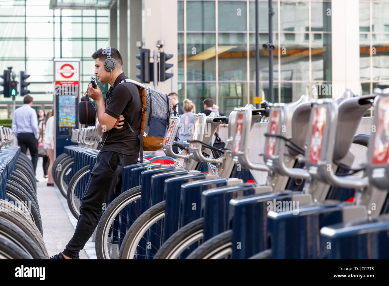 Londres, Royaume-Uni - 10 mai 2017 - Un jeune homme s'appuyant sur un vélo à Santander une station d'accueil à Canary Wharf Banque D'Images