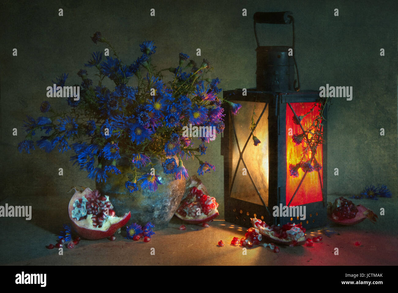 La vie toujours avec un bouquet de bleuet bleu dans un vieux pot en terre, une lanterne d'antiquités, ainsi que des morceaux de la rupture d'un rouge lumineux venu pomegran Banque D'Images