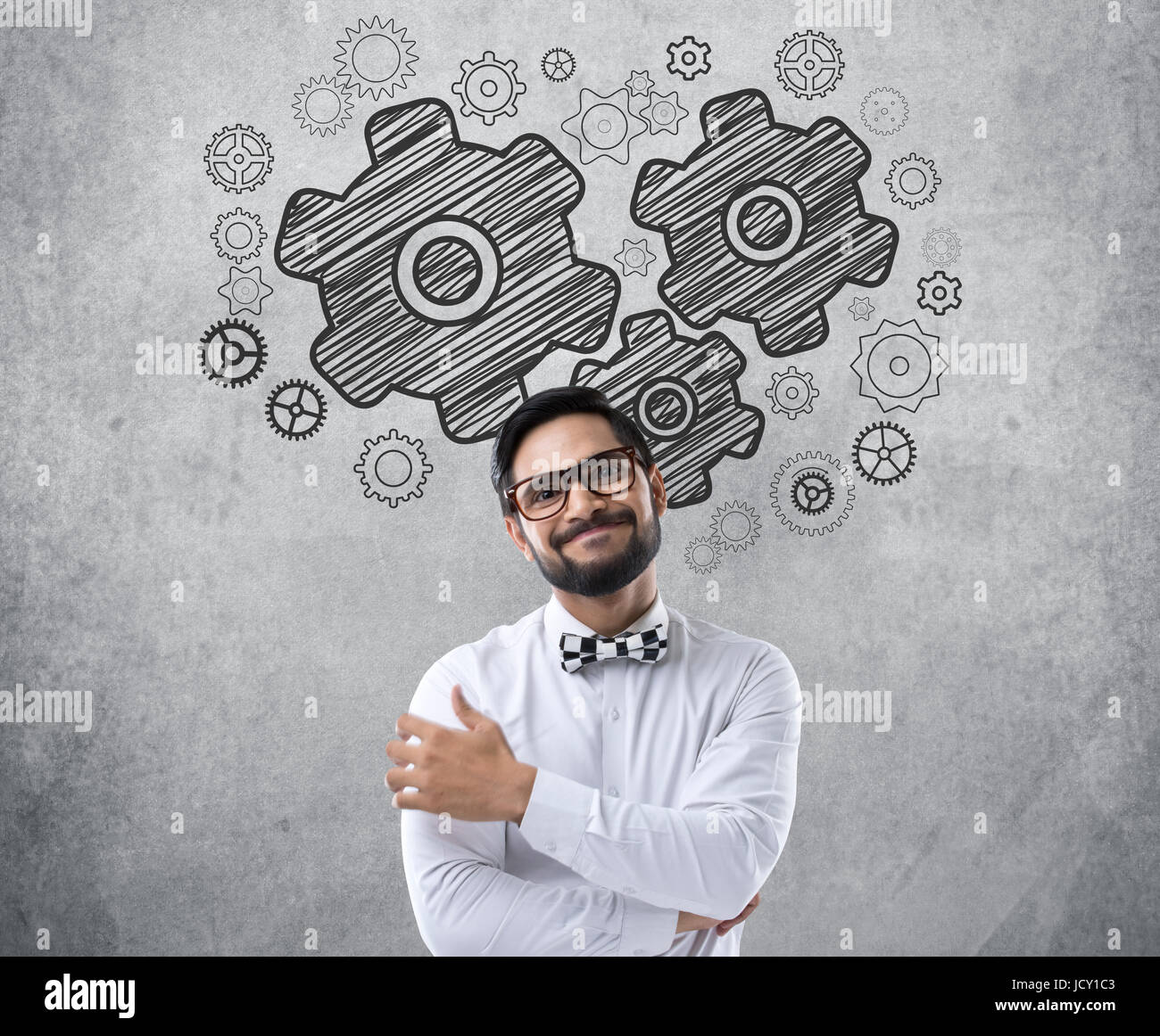 Portrait of smiling businessman with gear icônes sur mur Banque D'Images