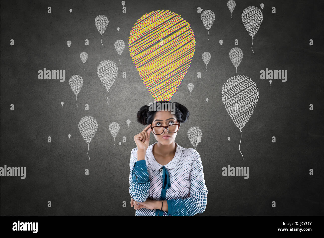 Portrait of businesswoman in front of blackboard chalk avec icônes de ballon Banque D'Images