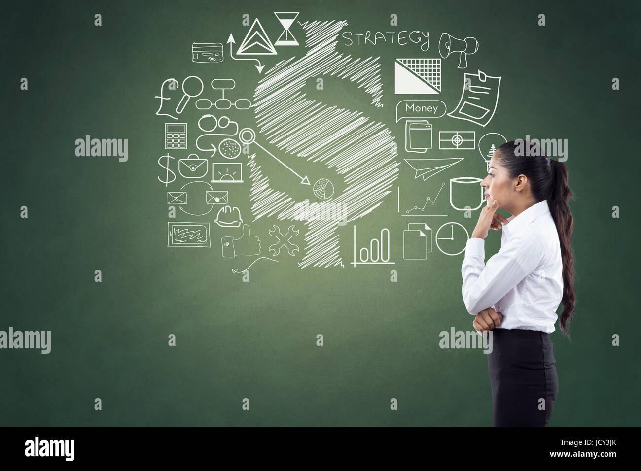 Vue latérale d'une businesswoman in front of chalkboard with business & finance icons Banque D'Images